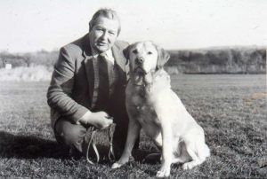 Derek Freeman Ireson kneeling next to a yellow lab.
